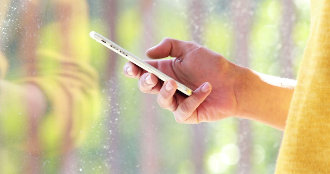 Close-up of Hand Holding Smartphone Near Window in Bright Daylight - Free Images, Stock Photos and Pictures on Pikwizard.com