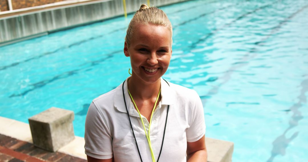 Female Lifeguard Smiling by Swimming Pool on Bright Day - Free Images, Stock Photos and Pictures on Pikwizard.com