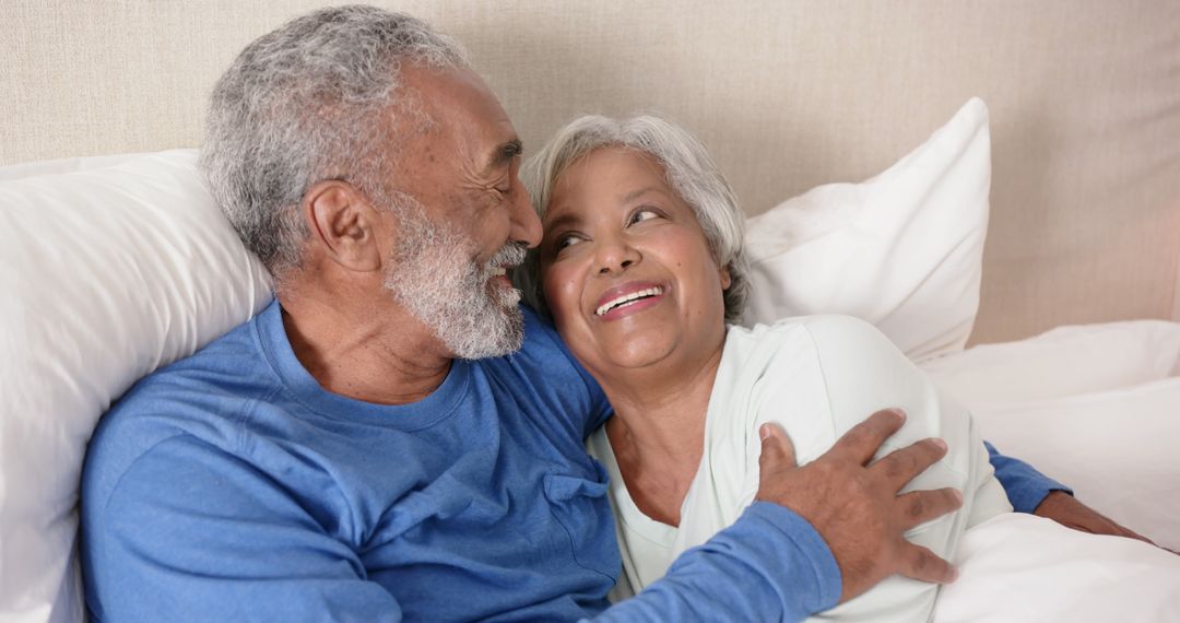 Senior Couple Embracing with Joyful Expressions in Bedroom