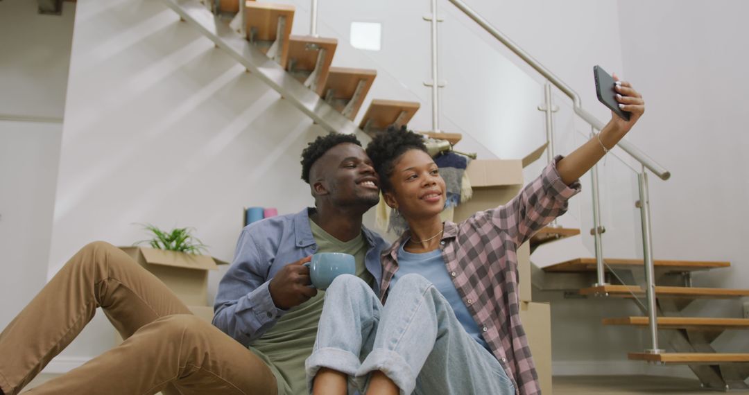 Image of happy african american couple taking selfie after moving into new house - Free Images, Stock Photos and Pictures on Pikwizard.com