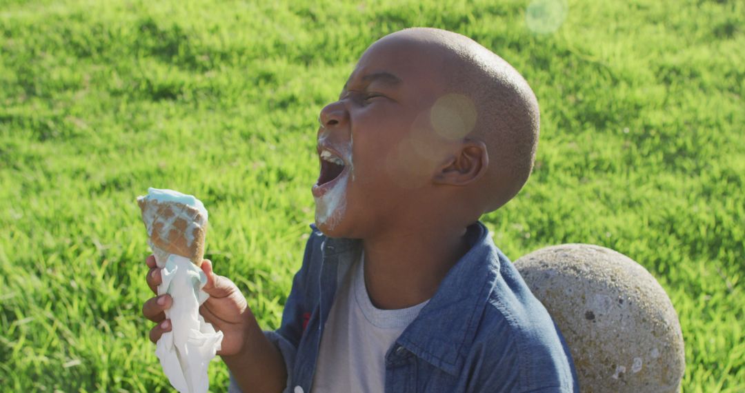 Joyful Child Laughing and Holding Ice Cream Cone Outdoors - Free Images, Stock Photos and Pictures on Pikwizard.com