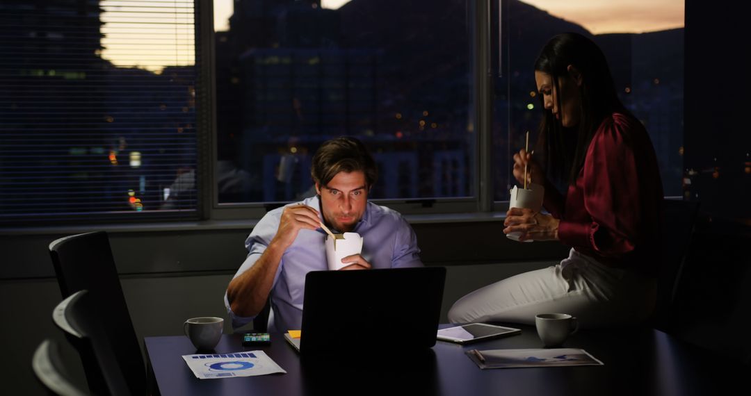 Colleagues Eating and Working Late in Office