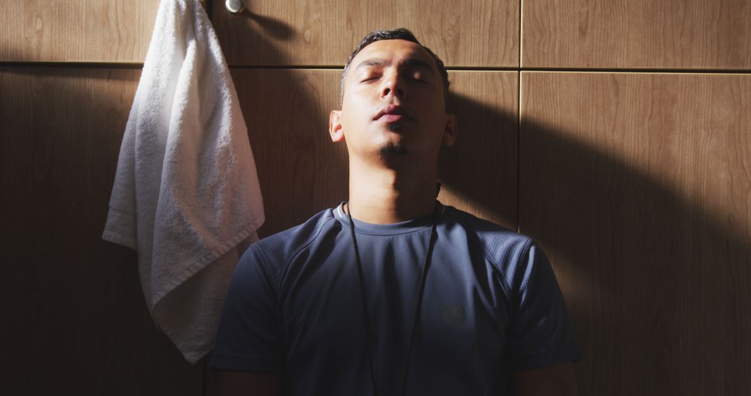 Athletic Man Resting Against Locker Room Wall - Free Images, Stock Photos and Pictures on Pikwizard.com