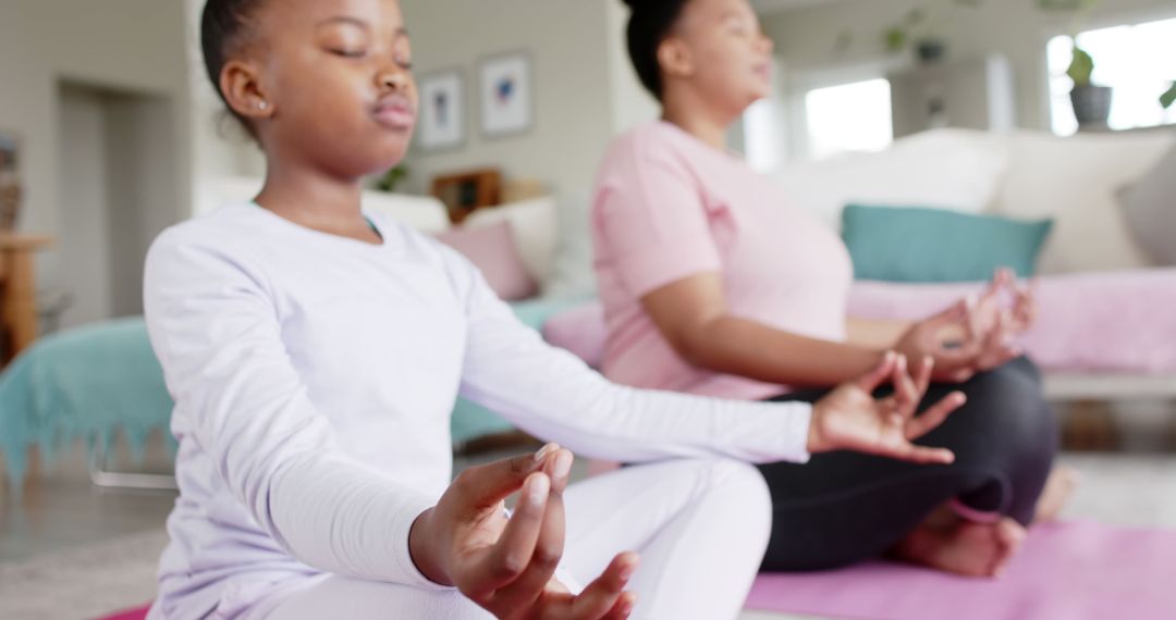 Mother and Daughter Meditating Together on Yoga Mats at Home - Free Images, Stock Photos and Pictures on Pikwizard.com