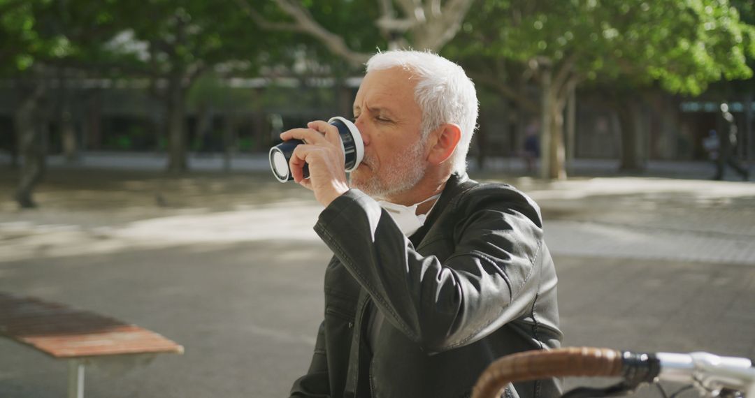 Middle-aged man enjoying coffee outdoors in urban park - Free Images, Stock Photos and Pictures on Pikwizard.com