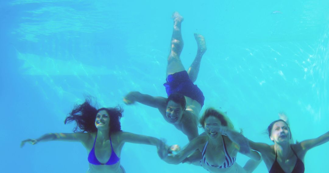 Four friends swimming underwater in pool - Free Images, Stock Photos and Pictures on Pikwizard.com