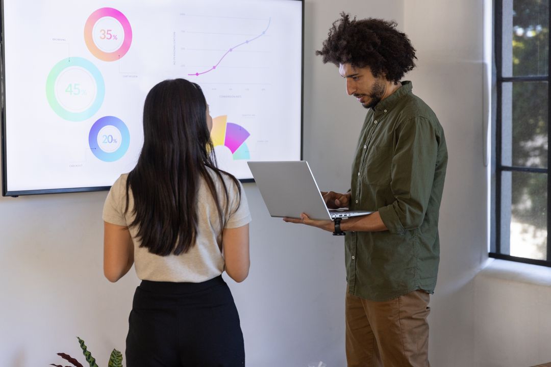Coworkers Analyzing Charts in Modern Office Environment