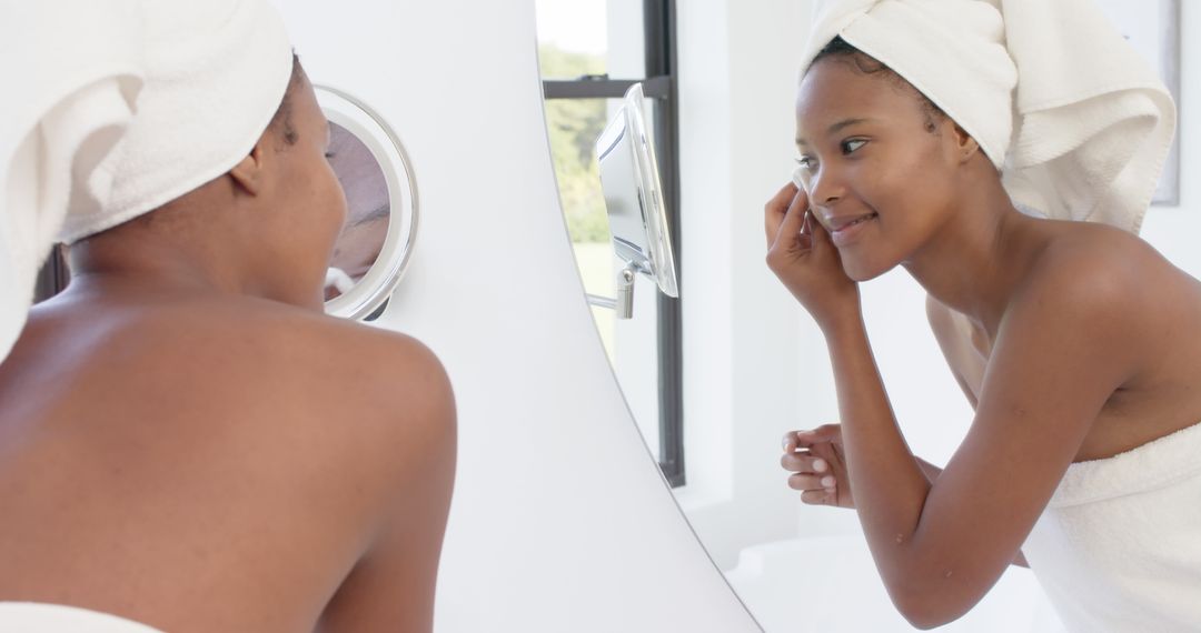 Woman Applying Makeup in Bathroom Mirror, Smiling and Wearing Towel - Free Images, Stock Photos and Pictures on Pikwizard.com