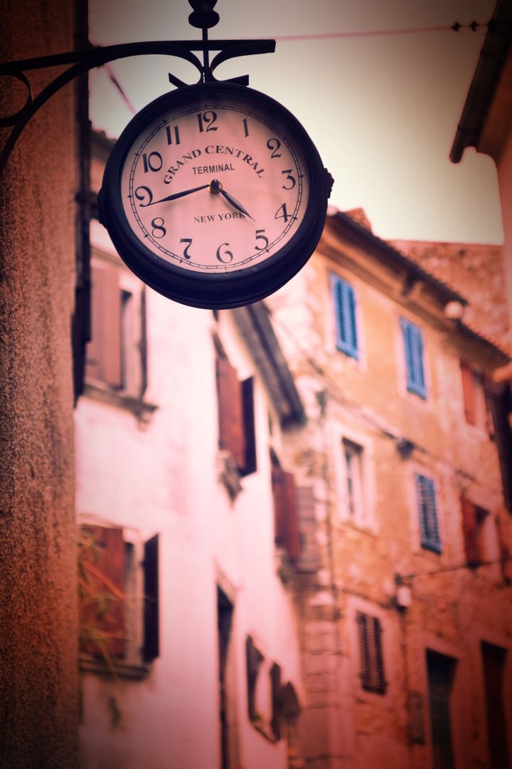 Vintage Clock on Street with Rustic Building and Warm Lighting - Free Images, Stock Photos and Pictures on Pikwizard.com