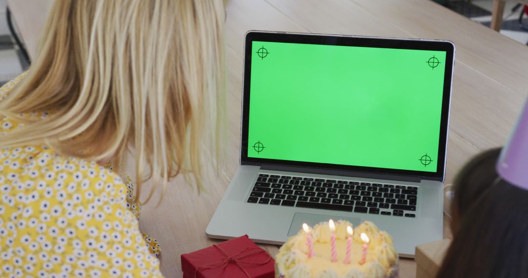 Woman Viewing Laptop with Green Screen at Birthday Party - Free Images, Stock Photos and Pictures on Pikwizard.com