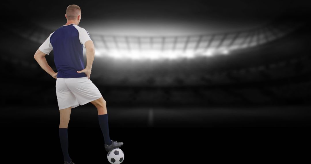 Soccer Player Standing with Ball Under Lights