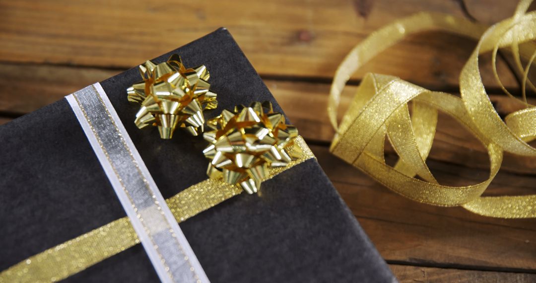 Gift Box with Golden Ribbon and Bow on Wooden Table - Free Images, Stock Photos and Pictures on Pikwizard.com