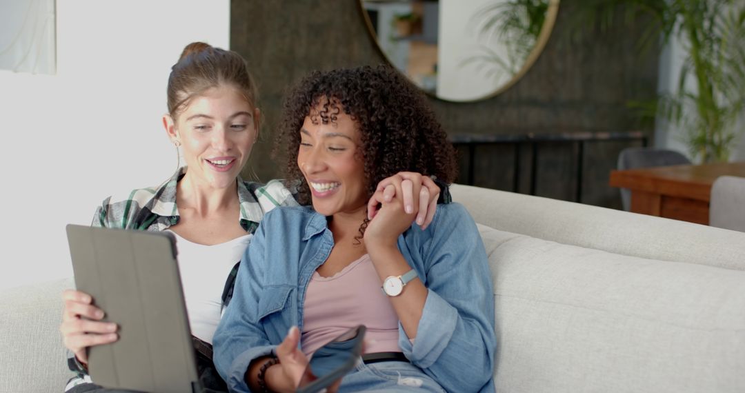 Diverse Women Relaxing on Sofa Sharing and Enjoying Technology