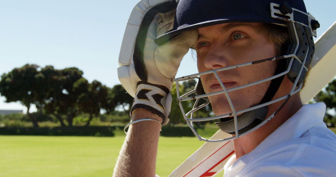 Cricket Player Wearing Helmet Preparing to Play on Sunny Field - Free Images, Stock Photos and Pictures on Pikwizard.com