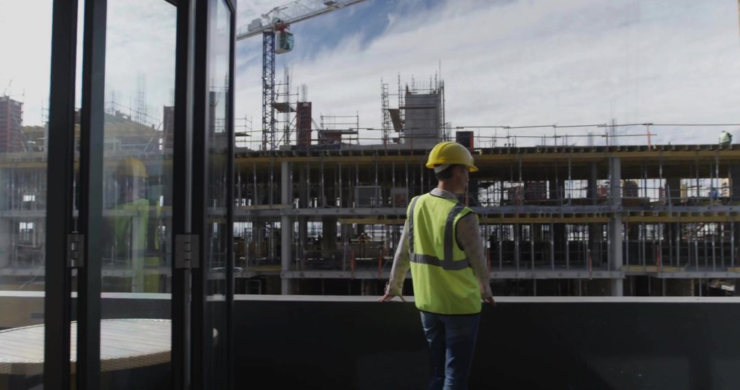 Construction Worker Overlooking Building Site with Scaffolding