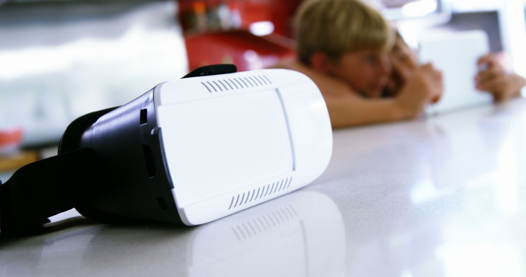 Virtual Reality Headset on White Kitchen Counter with Family in Background - Free Images, Stock Photos and Pictures on Pikwizard.com