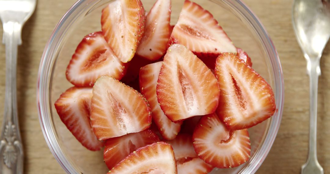 Close-up of strawberries slices in bowl on wooden background - Free Images, Stock Photos and Pictures on Pikwizard.com