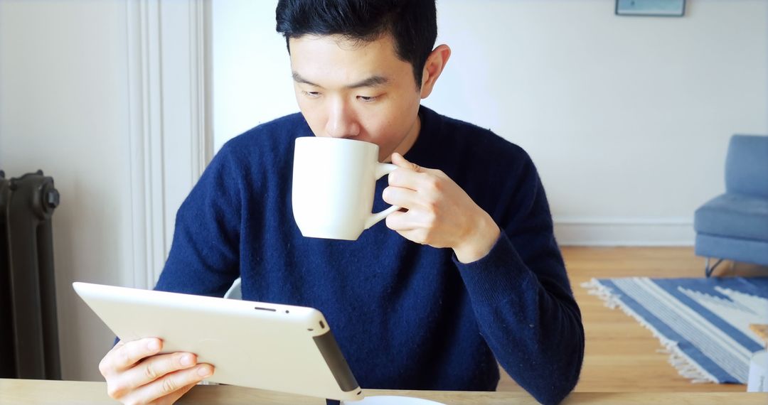 Man Drinking Coffee While Using Tablet at Home - Free Images, Stock Photos and Pictures on Pikwizard.com