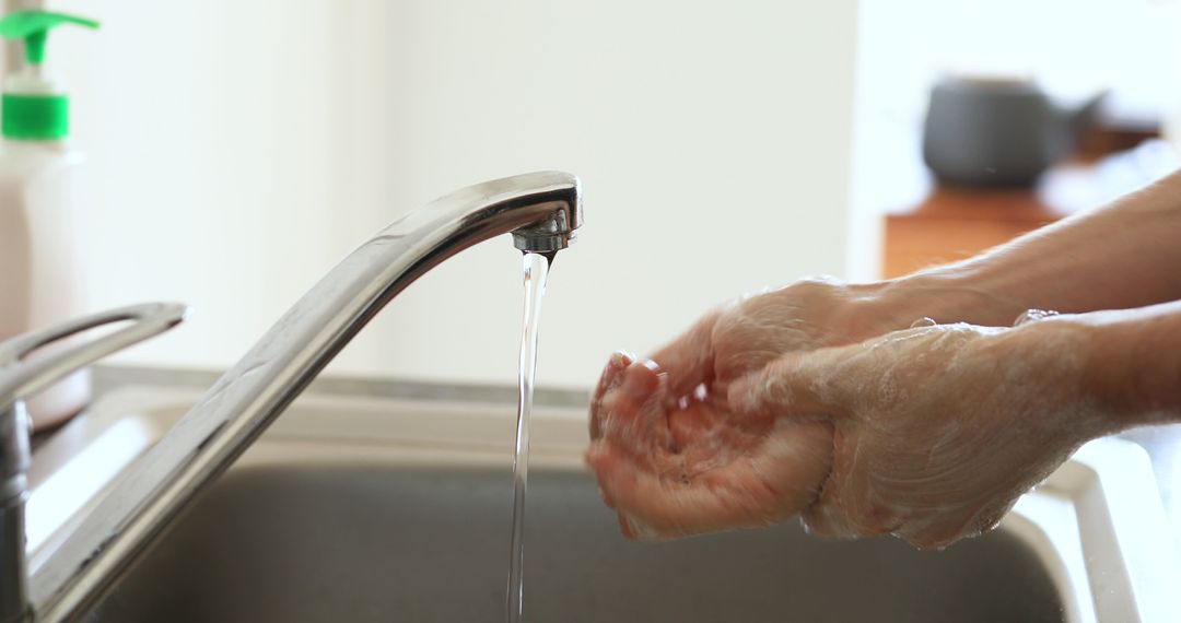 Person Washing Hands Under Running Faucet in Kitchen Sink - Free Images, Stock Photos and Pictures on Pikwizard.com