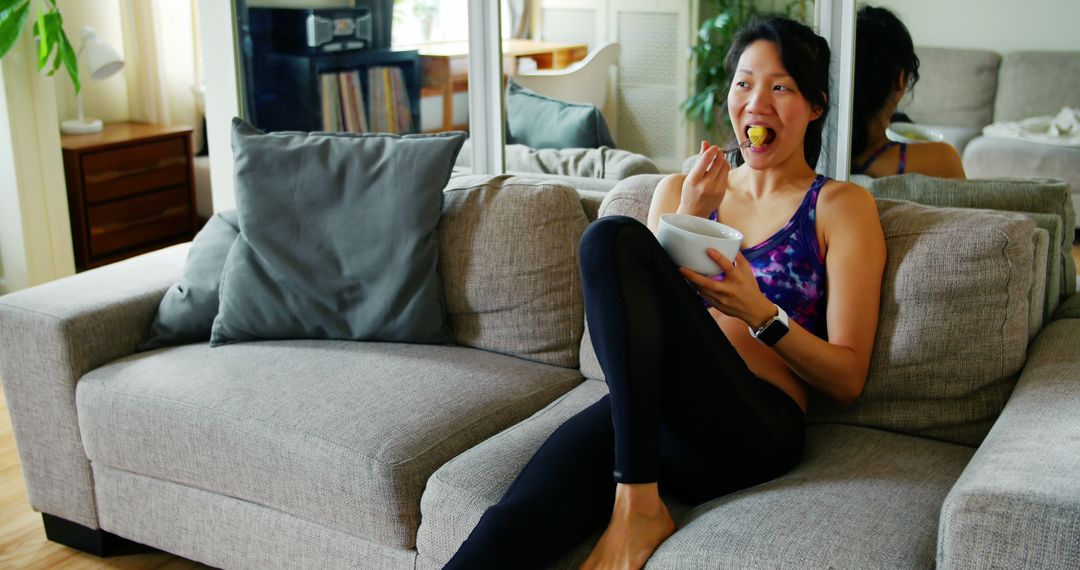 Woman Eating Healthy Snack on Couch in Cozy Living Room - Free Images, Stock Photos and Pictures on Pikwizard.com