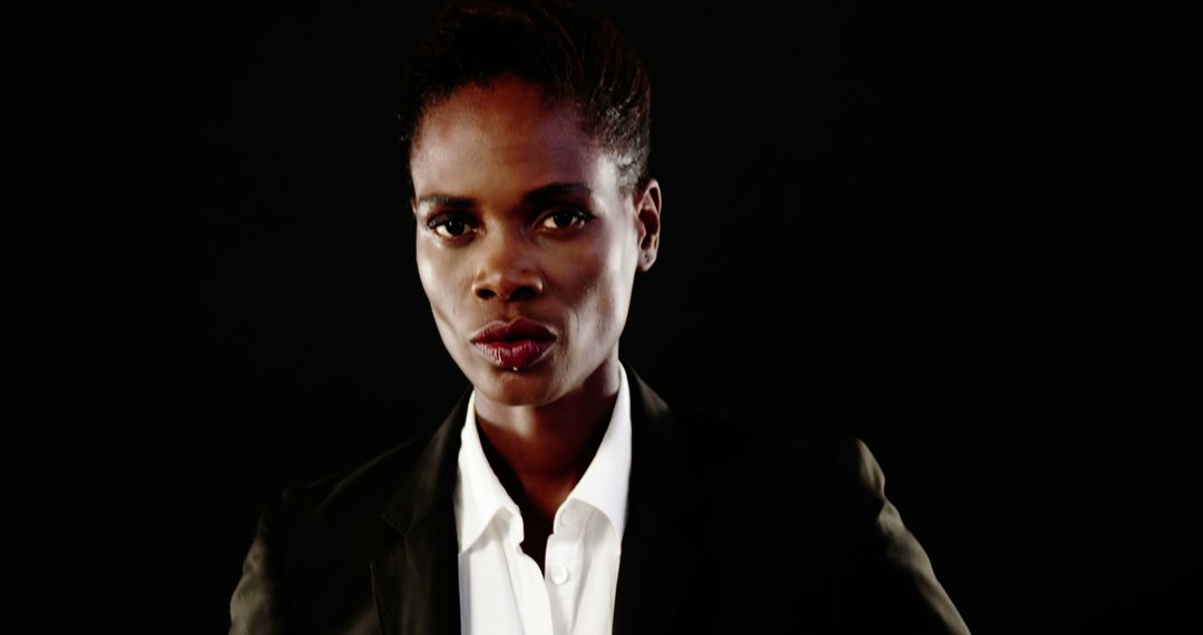 Confident African Woman in Suit with Serious Expression on Black Background - Free Images, Stock Photos and Pictures on Pikwizard.com