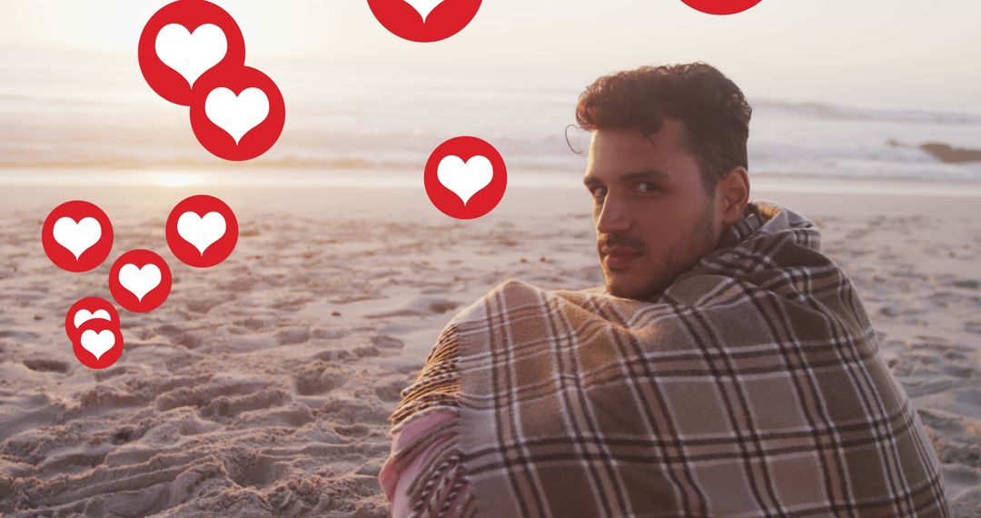 Man Wrapped in Plaid Blanket on Beach at Sunset