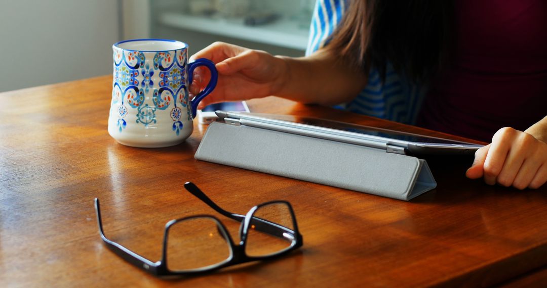 Woman Relaxing at Wooden Table with Tablet, Coffee, and Glasses - Free Images, Stock Photos and Pictures on Pikwizard.com