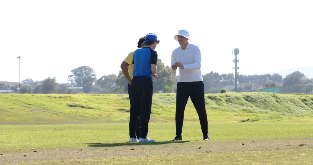 Diverse Teammates strategizing on Grassy Field in Caps