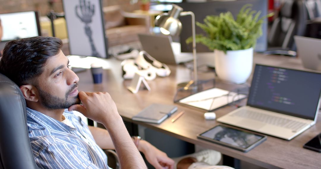 Man Contemplating Robotics and AI at Modern Workspace