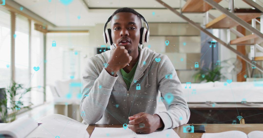 Young Man with Headphones Studying Online at Home Desk