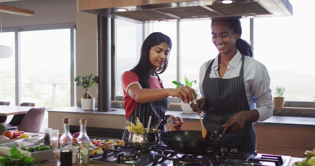 Two Smiling Women Cooking Together in Modern Kitchen - Free Images, Stock Photos and Pictures on Pikwizard.com