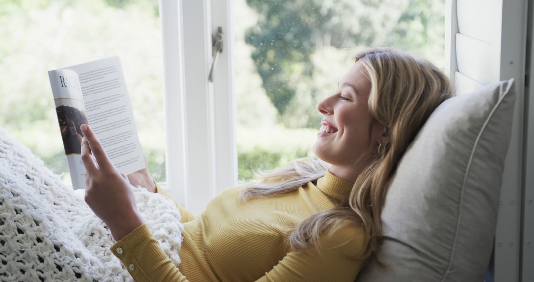 Woman Relaxing by Window Reading Magazine - Free Images, Stock Photos and Pictures on Pikwizard.com