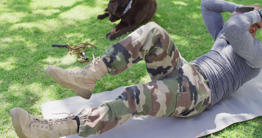 African american male soldier exercising and doing sit ups with dog in garden - Free Images, Stock Photos and Pictures on Pikwizard.com