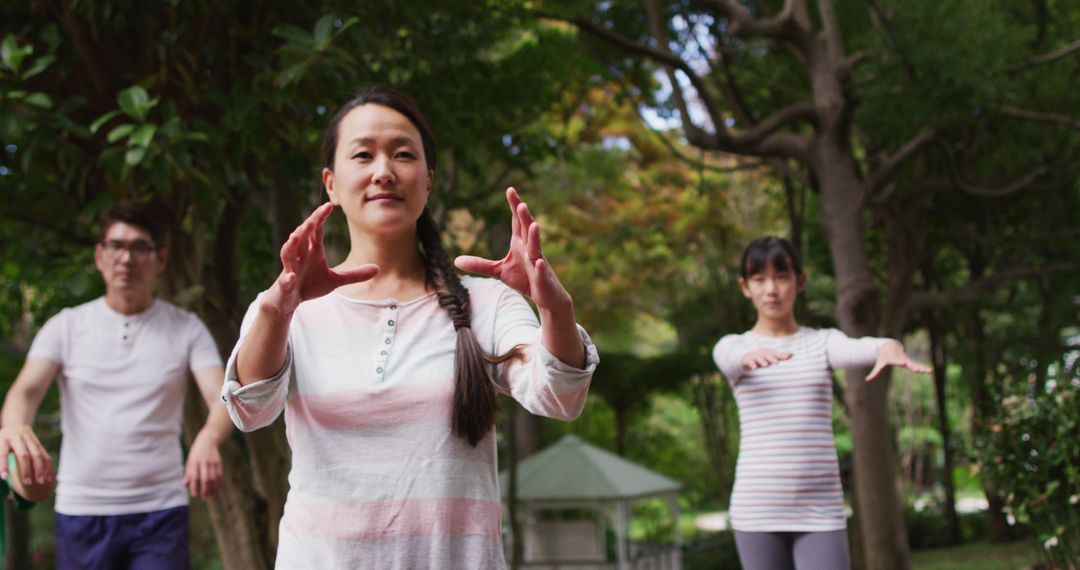 Happy asian parents exercising in garden with son and daughter, practicing tai chi together - Free Images, Stock Photos and Pictures on Pikwizard.com