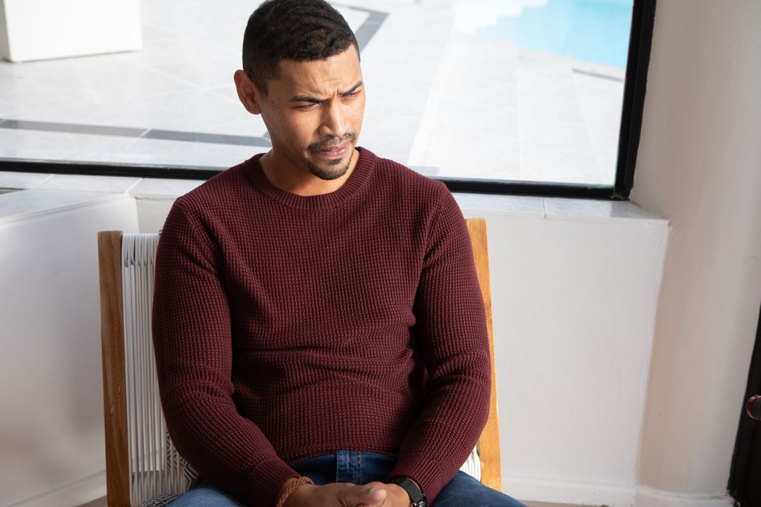 Man Pondering by Poolside Window in Modern Home Interior