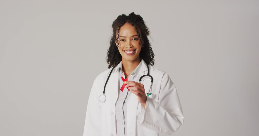Image of smiling biracial female doctor holding orange kidney cancer ribbon - Free Images, Stock Photos and Pictures on Pikwizard.com