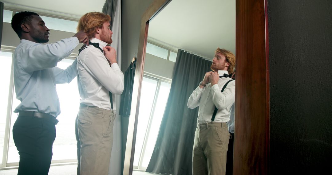 Groom and Best Man Tying Bow Tie in Modern Interior