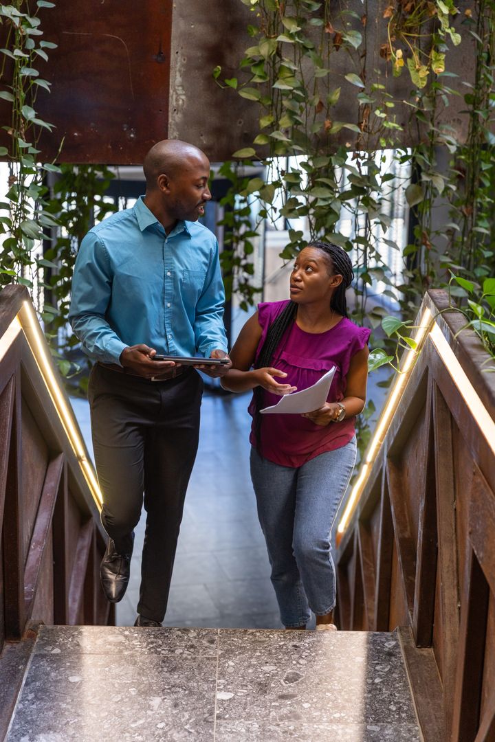 Coworkers Collaborating While Climbing Innovative Office Stairs