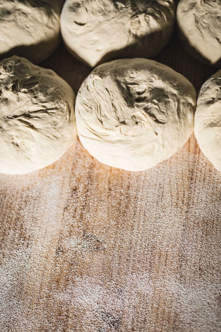 Fresh Dough Balls on Floured Wooden Counter in Bakery - Free Images, Stock Photos and Pictures on Pikwizard.com