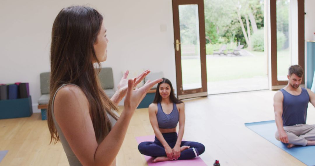 Yoga Instructor Leading Diverse Class with Enthusiastic Gesture