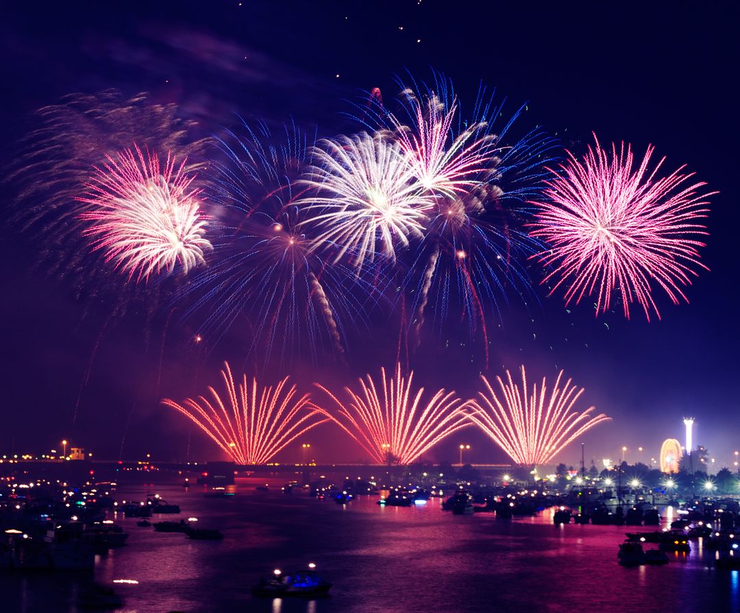 Vibrant Nighttime Celebration with Colorful Fireworks Display over Water