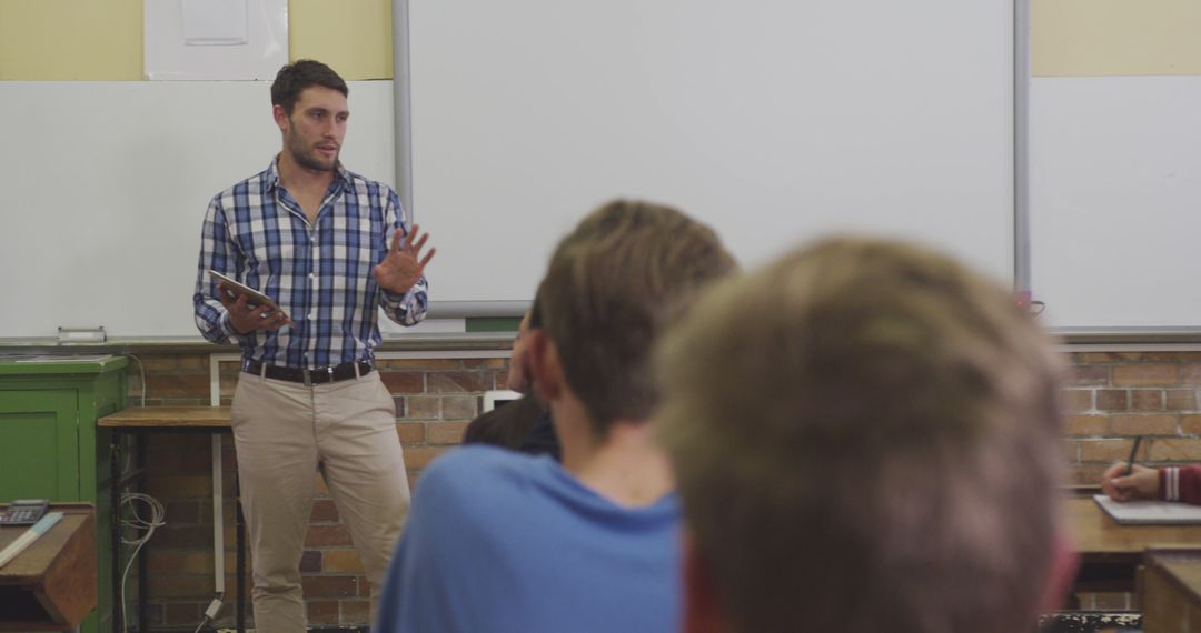 Male Teacher Giving Lesson to Attentive Students in Classroom Setting - Free Images, Stock Photos and Pictures on Pikwizard.com