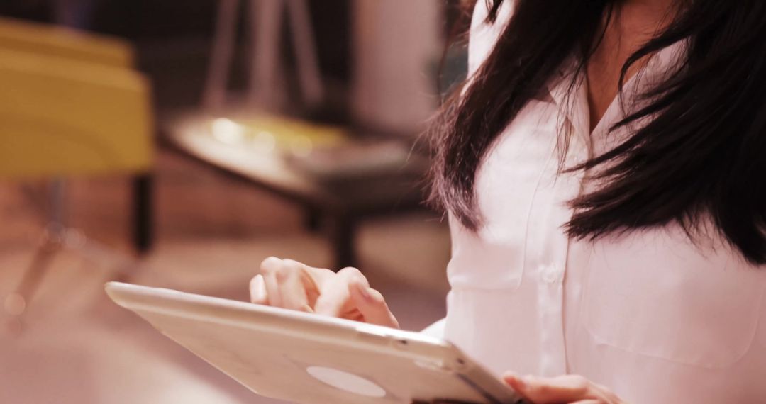 Professional Woman Tapping Tablet in Modern Workspace