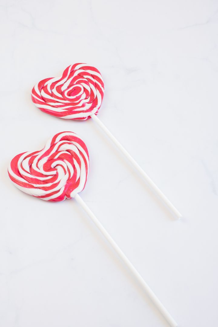 Red and White Heart Shaped Lollipops on Marble Surface