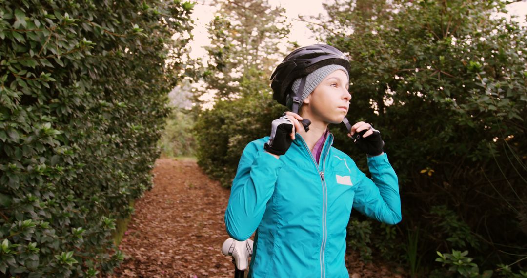 Female Cyclist Adjusting Helmet on Forest Trail - Free Images, Stock Photos and Pictures on Pikwizard.com