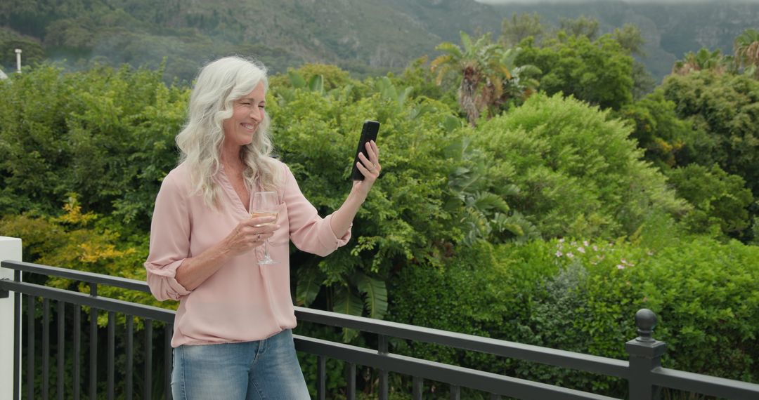 Woman Enjoying Scenic Mountain View While Video Calling on Smartphone