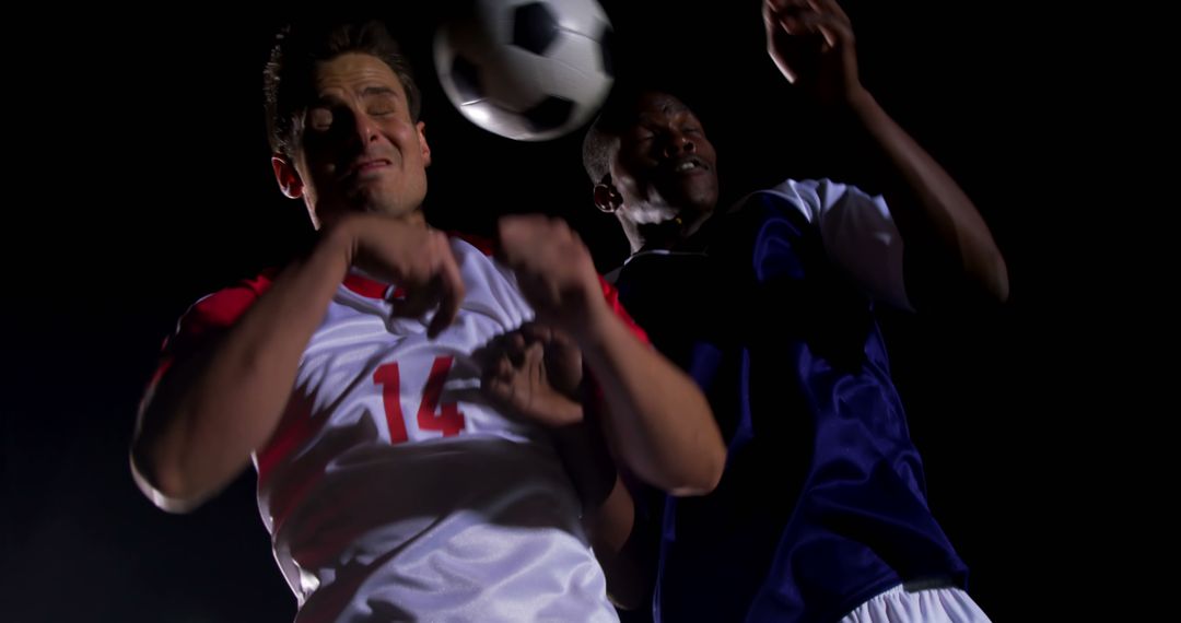 Two Male Soccer Players Competing For Ball During Night Match - Free Images, Stock Photos and Pictures on Pikwizard.com