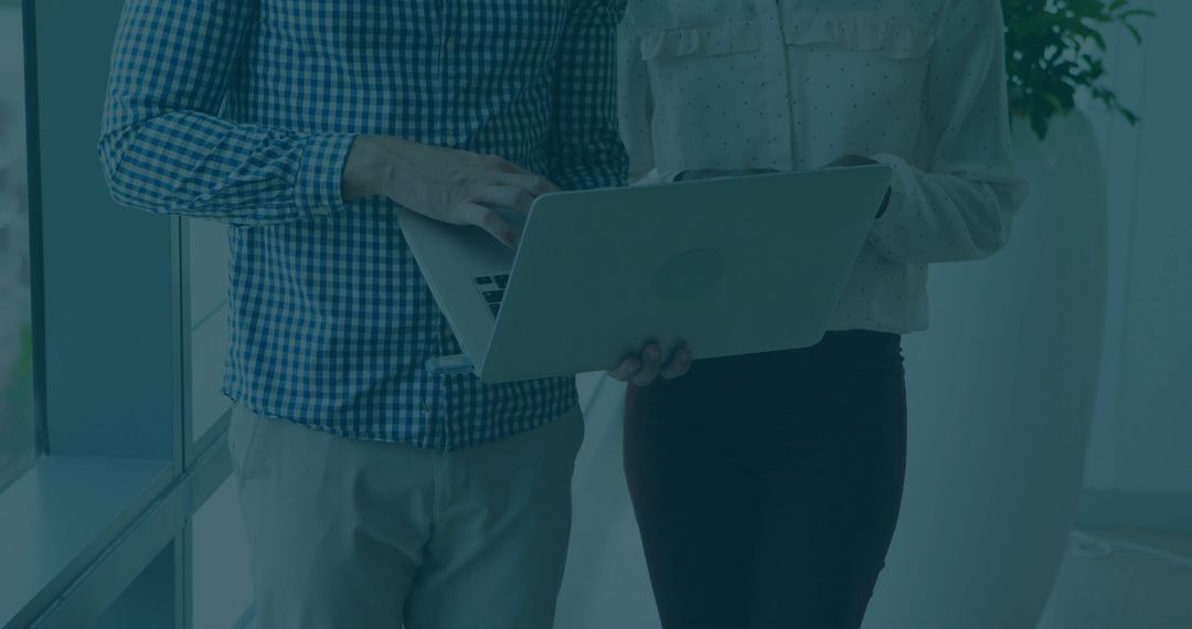 Business Colleagues Collaborating with Laptop in Modern Office Environment