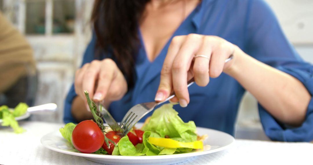 Woman eating a fresh meal at table - Free Images, Stock Photos and Pictures on Pikwizard.com