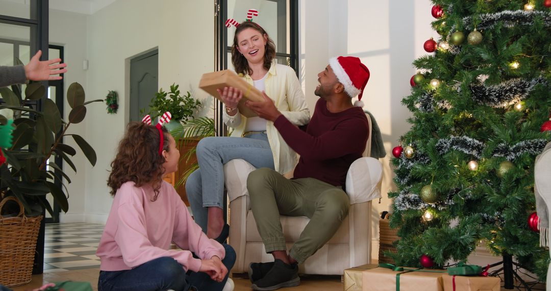 Diverse Family Exchanging Christmas Gifts by Tree